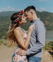 Load image into Gallery viewer, A couple holding one another on a cliff overlooking the sea on Oahu with the woman wearing a small flower crown
