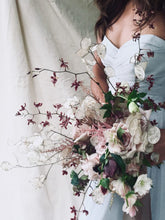 Load image into Gallery viewer, A bridesmaid wearing a light blue dress holding a bouquet of dahlias and orchids designed by SF.Fleur
